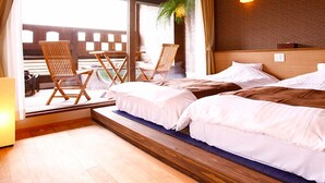 A hotel room with a large sliding glass door leading to a balcony, two single beds, a wooden headboard, and a potted plant. - Yuyuan (Kirishima)