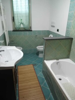 Kombination af bruser/badekar, hårtørrer, bidet, håndklæder