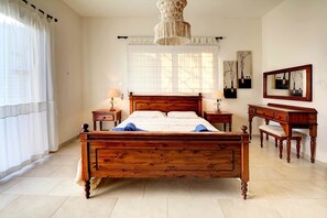 Un dormitorio con cama de madera, mesitas de noche, cómoda y espejo.