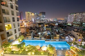 A nighttime cityscape with a swimming pool surrounded by buildings. - Celine Home Millenium (Ho Chi Minh City)