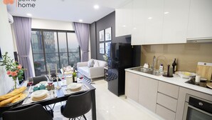 A modern kitchen with a dining area, large windows, and a view of the city. - Celine Home Millenium (Ho Chi Minh City)