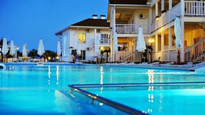 A swimming pool with lounge chairs and umbrellas, a multi-story building with balconies, and a clear sky. - GoodZone Club Hotel Zatoka (Zatoka)