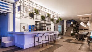 A modern bar area with a white counter, bar stools, and a staircase leading to an upper level. - GoodZone Club Hotel Zatoka (Zatoka)