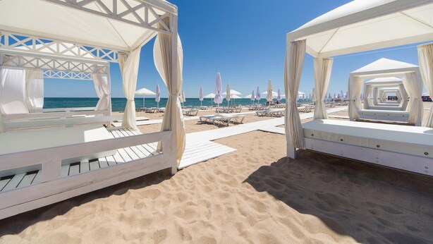 A beach with white canopies and lounge chairs, a clear blue sky, and the ocean in the background. - GoodZone Club Hotel Zatoka (Zatoka)