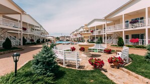 A resort with multiple-story buildings, outdoor swimming pool, and a central fountain surrounded by benches and flower beds. - GoodZone Club Hotel Zatoka (Zatoka)