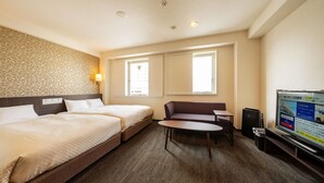 A hotel room with two beds, a sofa, a small table, and a TV. - Sanco INN Numazu-ekimae (Numazu)