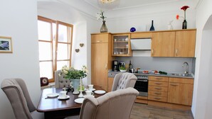 A modern kitchen with wooden cabinets, a dining table with chairs, and a window with a view. - Ultra Alpes (Rottenbuch)