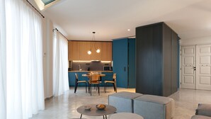 A modern living room with a dining area, a kitchen, and a large grey cabinet. - Syntagma Square Modern Apartments (Athens)