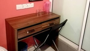 A compact room with a wooden desk, a mirror, and a small trash bin. - My Home Hotel - Setapak (Kuala Lumpur)