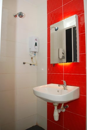 A bathroom with a white sink, a mirror, and a red-tiled wall. - My Home Hotel - Setapak (Kuala Lumpur)