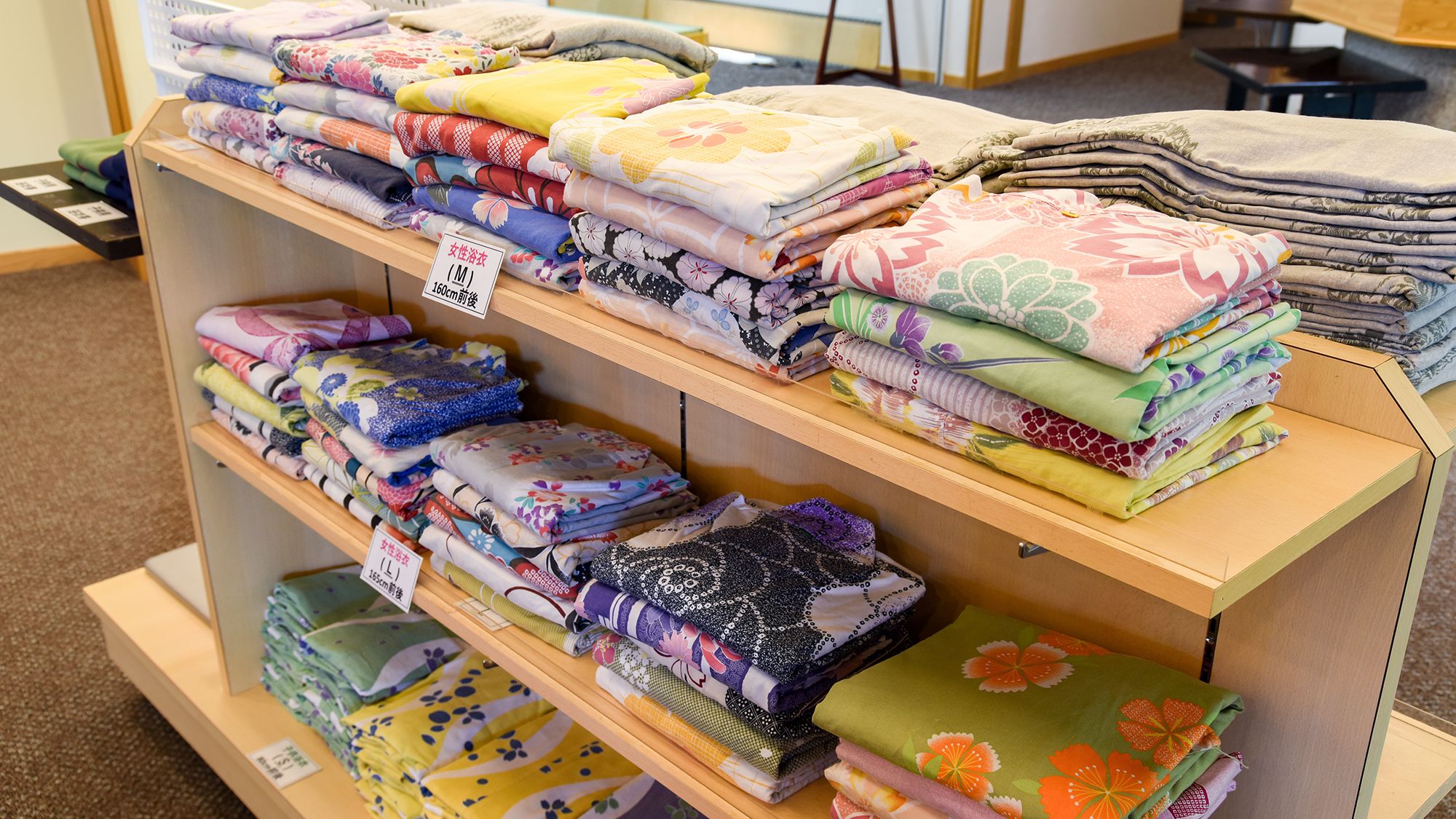 A display of folded bedding in various patterns and colors.