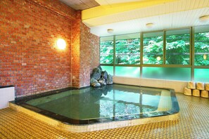 A spa area with a brick wall, a glass-enclosed hot tub, and a view of greenery through large windows. - Hayataro Onsen Komagane Retreat Suzuranso (Komagane)