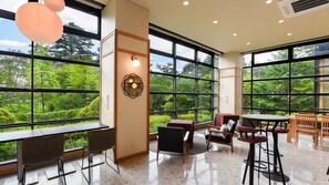 Una habitación amplia con ventanas grandes, un comedor y una barra.