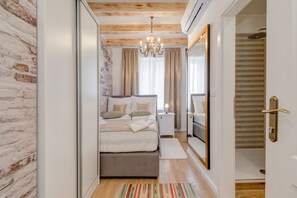 A bedroom with a bed, bedside table, and a mirror. - Le Monde Luxury Accommodation (Split)