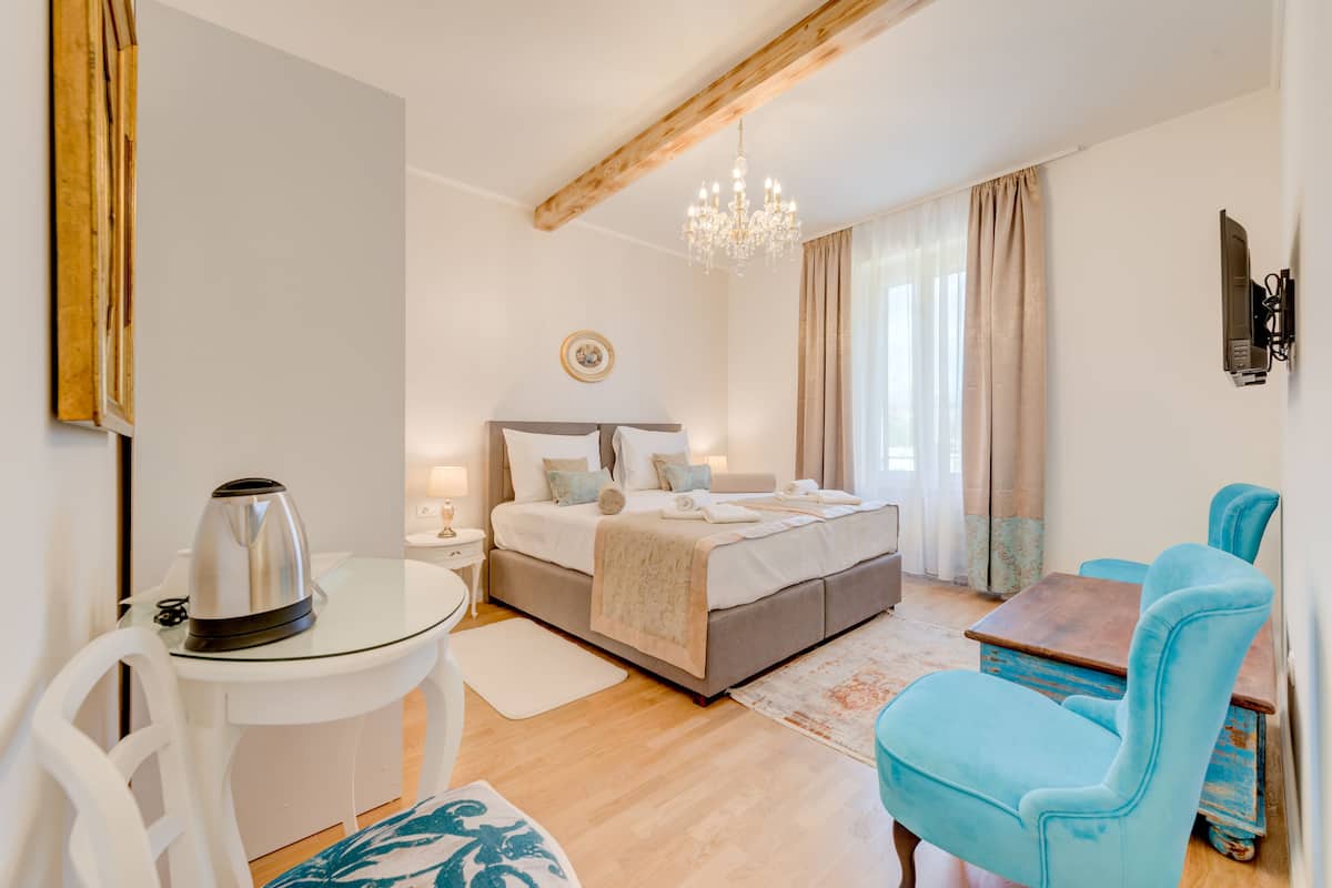 A bedroom with a bed, bedside table, and a chair.