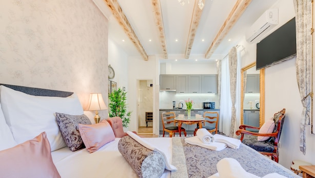 A hotel room with a bed, a desk, a chair, and a view of the kitchen. - Le Monde Luxury Accommodation (Split)