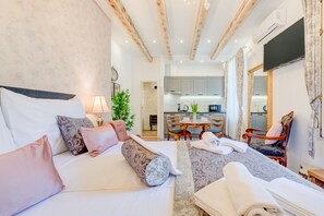 Una habitación de hotel con cama, escritorio, silla y vista a la cocina.