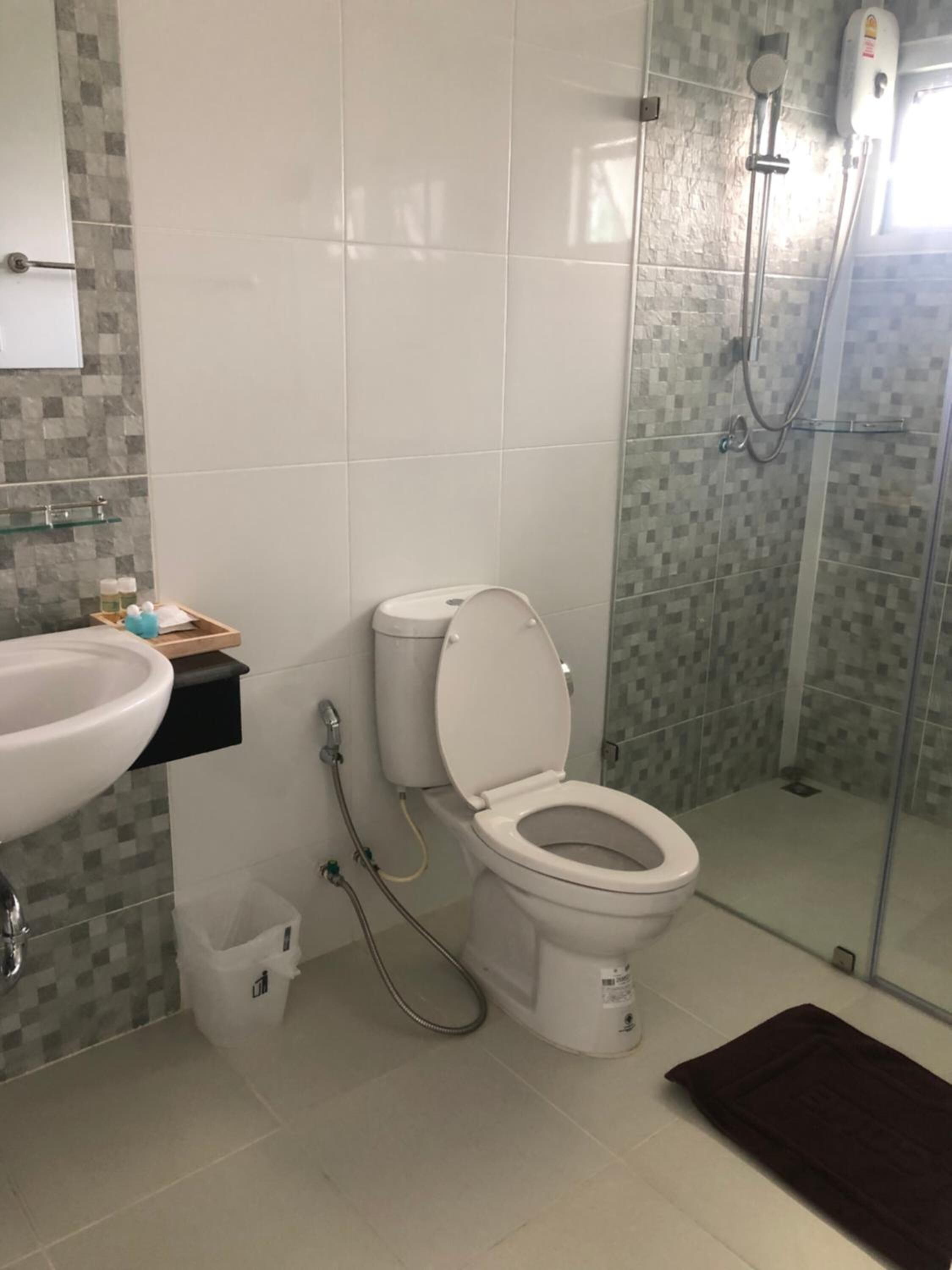 A bathroom with a toilet, sink, and shower.