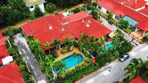 A residential area with red-roofed houses, a swimming pool, and lush greenery. - Siri Villas (Pattaya)