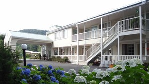A two-story building with a covered entrance and a staircase leading to the upper floor. - Family Lodge Hatagoya Nikko Kinugawa (Nikko)