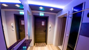 A hotel bathroom with two doors, a mirror, a sink, and a shower area. - Blissberg Winterberg (Winterberg)