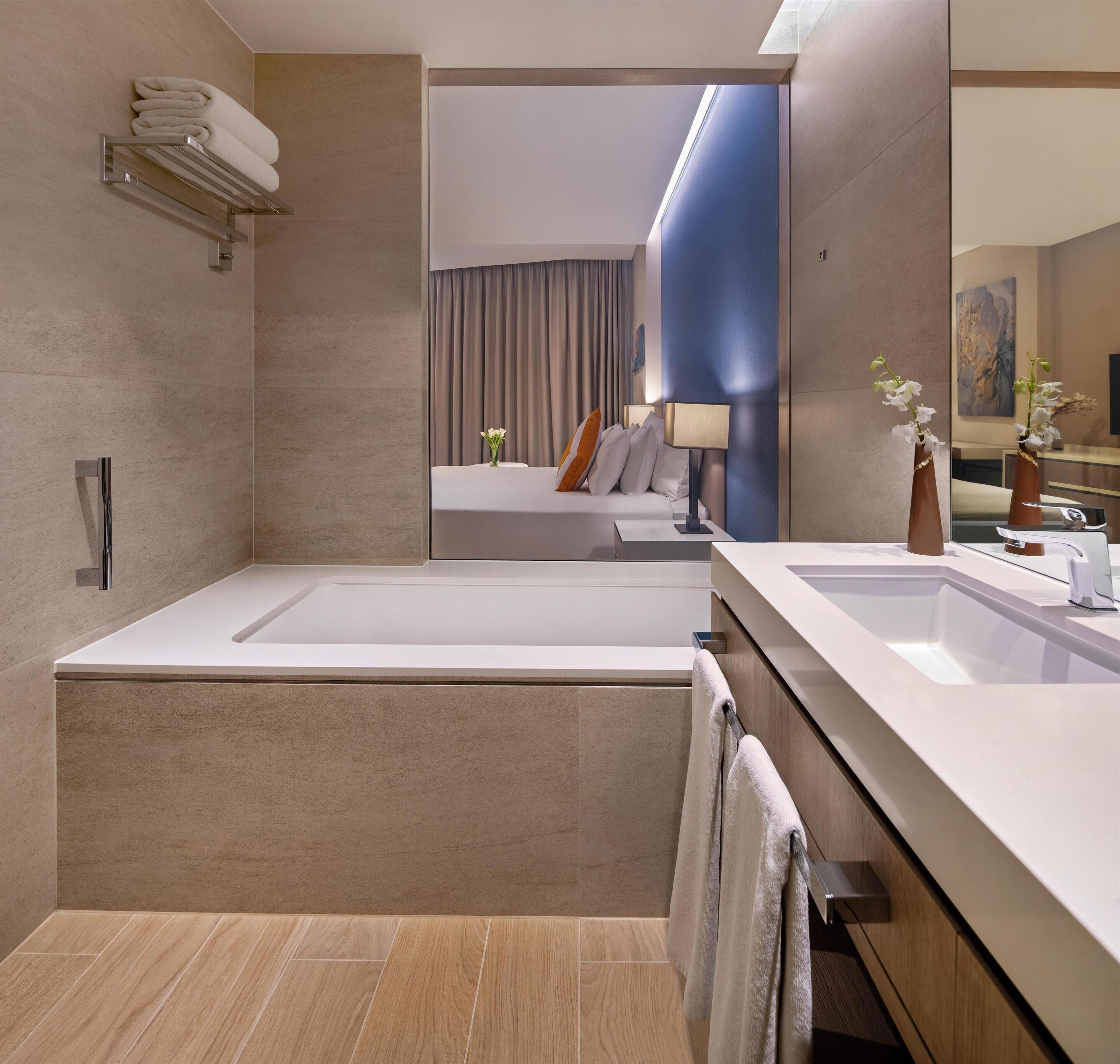 Ein modernes Badezimmer mit einer großen Badewanne, zwei Waschbecken und einem Spiegel.