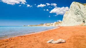 A beach with white cliffs, clear blue sky, and calm sea. - Villa Aethra (Kefalonia)