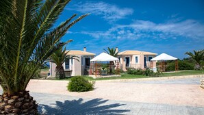 Ein Resort mit mehreren Villen, jede mit einem Ziegeldach und einer überdachten Außenbereich-Sitzgruppe.