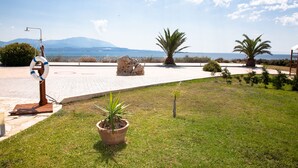 A landscaped area with a lifebuoy, a palm tree, and a stone structure.