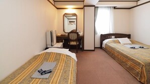A hotel room with two single beds, a desk with a chair, a mirror, and a window with curtains. - Niigata Hotel Terminal Inn (Niigata)