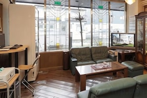 A modern interior with a sofa, a coffee table, and a television. - Hotel Terminal Inn (Niigata)
