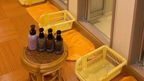 A room with sliding doors, a small table with bottles, and yellow baskets on the floor. - Niigata Hotel Terminal Inn (Niigata)