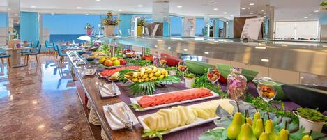 A buffet with various fruits, vegetables, and prepared dishes.