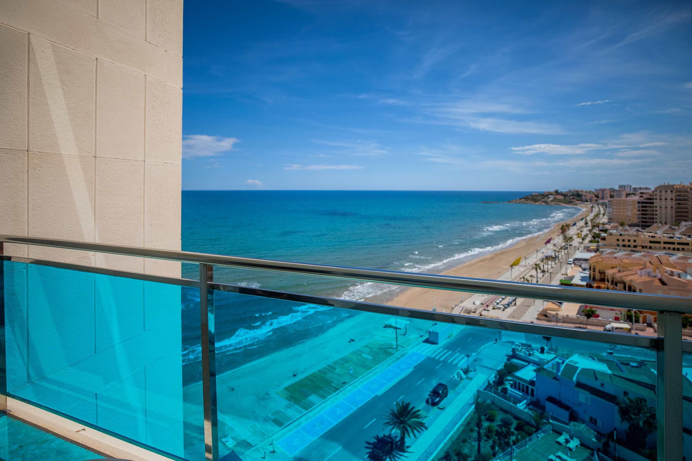 Ein Balkon mit Blick auf Strand und Meer.