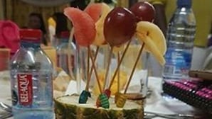 A pineapple centerpiece with colorful balloons on a white plate. - Trust Lodge (Sekondi-Takoradi)