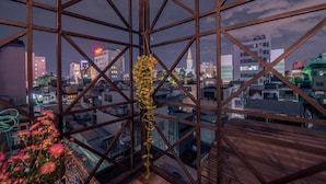 Un edificio alto con vistas a un paisaje urbano a través de una estructura de ventanales geométricos.