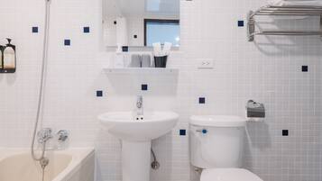 A bathroom with a bathtub, sink, and toilet.