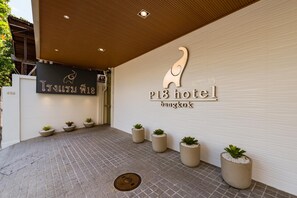 A hotel entrance with a modern design, featuring a large elephant sculpture and the hotel's name. - P18 Hotel (Bangkok)