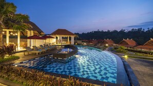 A resort pool area with lounge chairs, a hot tub, and a checkered pool floor.