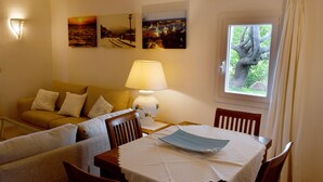 A cozy living room with a sofa, a table with a lamp, and two wall-mounted pictures. - Belvedere (Arzachena)