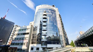 Un hôtel moderne à la façade incurvée, doté de nombreux balcons et d’une enseigne bien visible au sommet.
