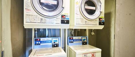 Two front-loading washing machines with control panels, one of which has a red "X" marking.