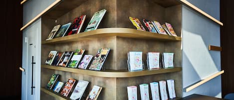 A modern interior with curved shelving displaying various books and magazines.