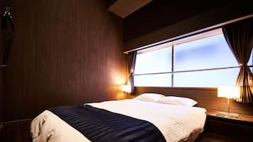 A hotel room with a bed, nightstands, and a window.