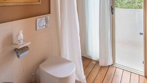 Une salle de bain équipée de toilettes, d’un bidet et d’un lavabo. Elle comprend une douche avec une porte en verre et offre une vue sur un paysage montagneux.