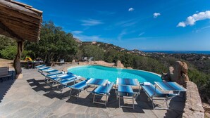 A pool area with lounge chairs and a view of the landscape. - Villa Noelia (Arzachena)