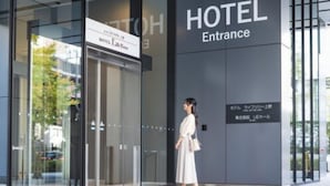 A modern hotel entrance with a glass facade and a sign indicating the entrance. - Hotel Crown Hills Ueno Premier (Tokyo)