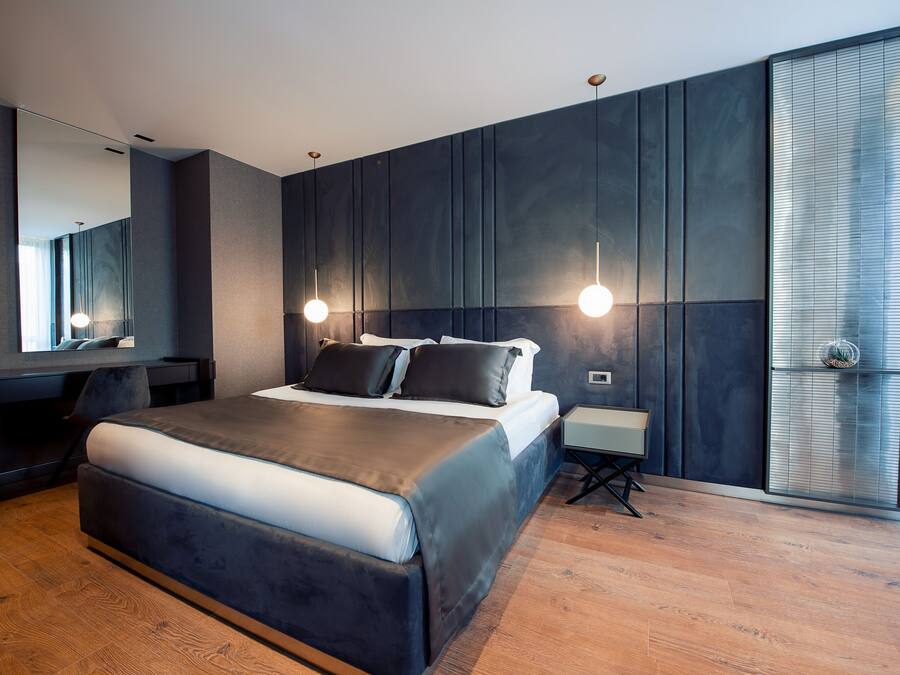 Un dormitorio moderno con una cama grande, un escritorio y un espejo.