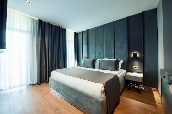 Exclusieve suite | Een minibar, een kluis op de kamer, een bureau, geluiddichte muren