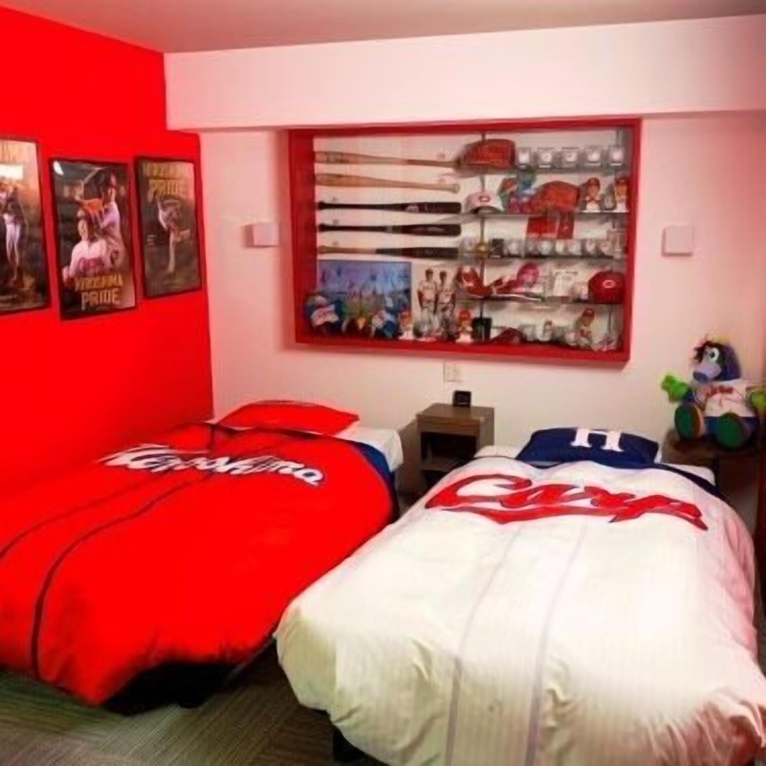 Een slaapkamer met twee bedden, een raam met uitzicht op een stadsbeeld, en een plank met diverse spullen.